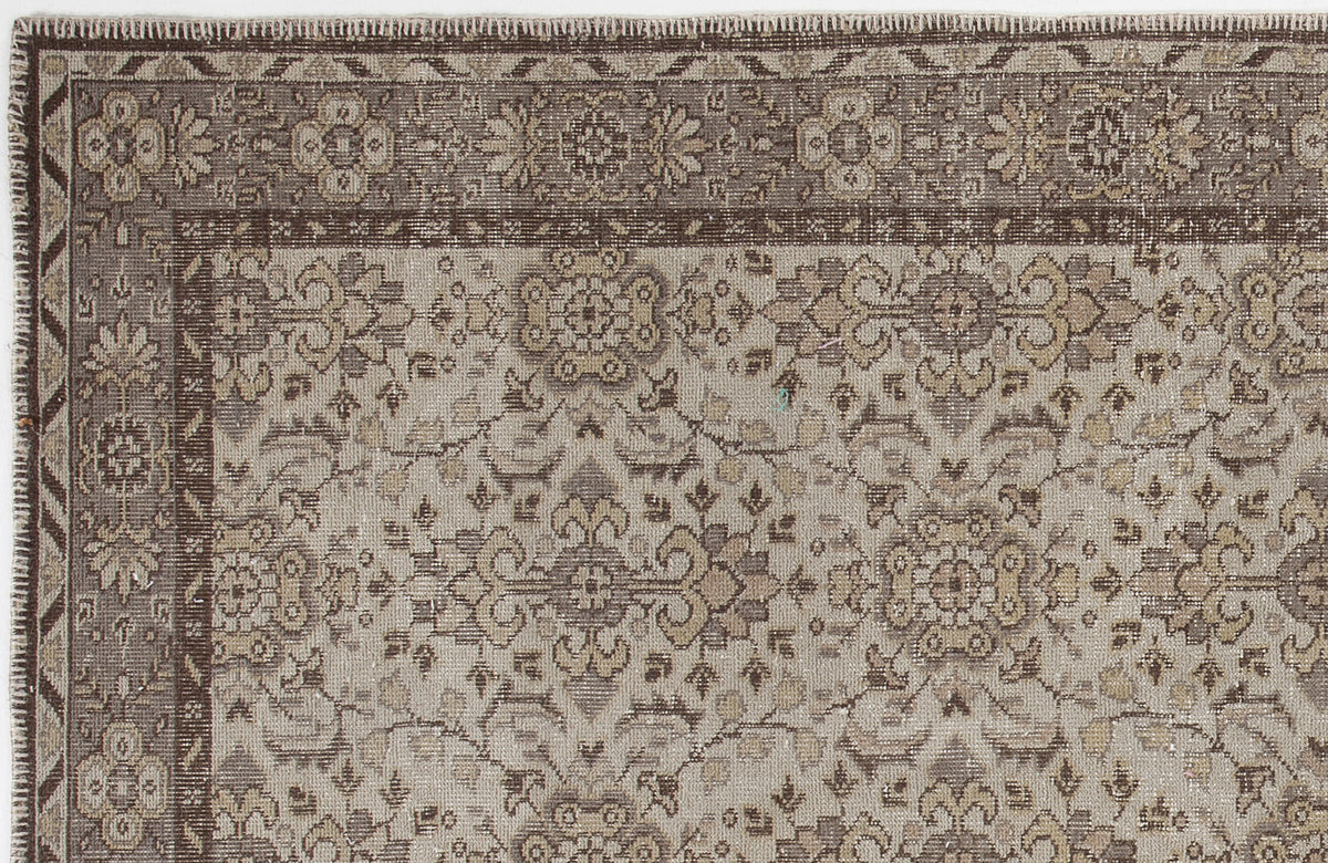 Brown and beige traditional rug with a distressed floral medallion pattern and a detailed geometric border.