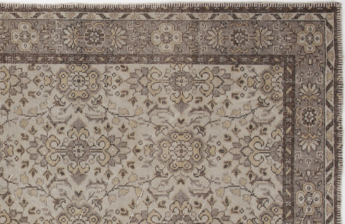 Load image 1 in gallery view. Taupe and brown traditional rug with a distressed floral medallion pattern and a geometric border.