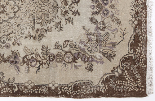 Load image 1 in gallery view. Beige and brown vintage-style rug with a distressed floral medallion pattern and fringed edge.