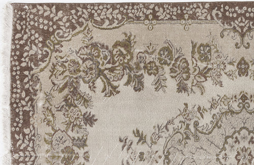 Load image 1 in gallery view. Beige and brown traditional rug with a distressed floral medallion pattern and fringed edge.