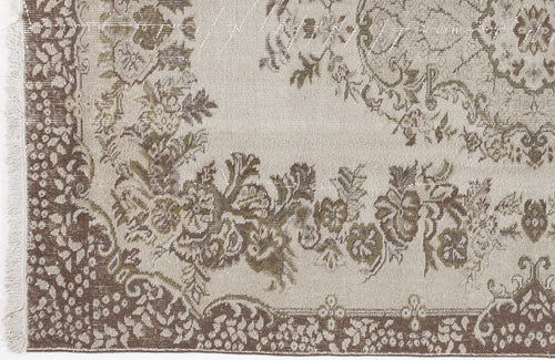 Load image 1 in gallery view. Beige and brown distressed rug with a traditional floral medallion pattern and fringed edge.