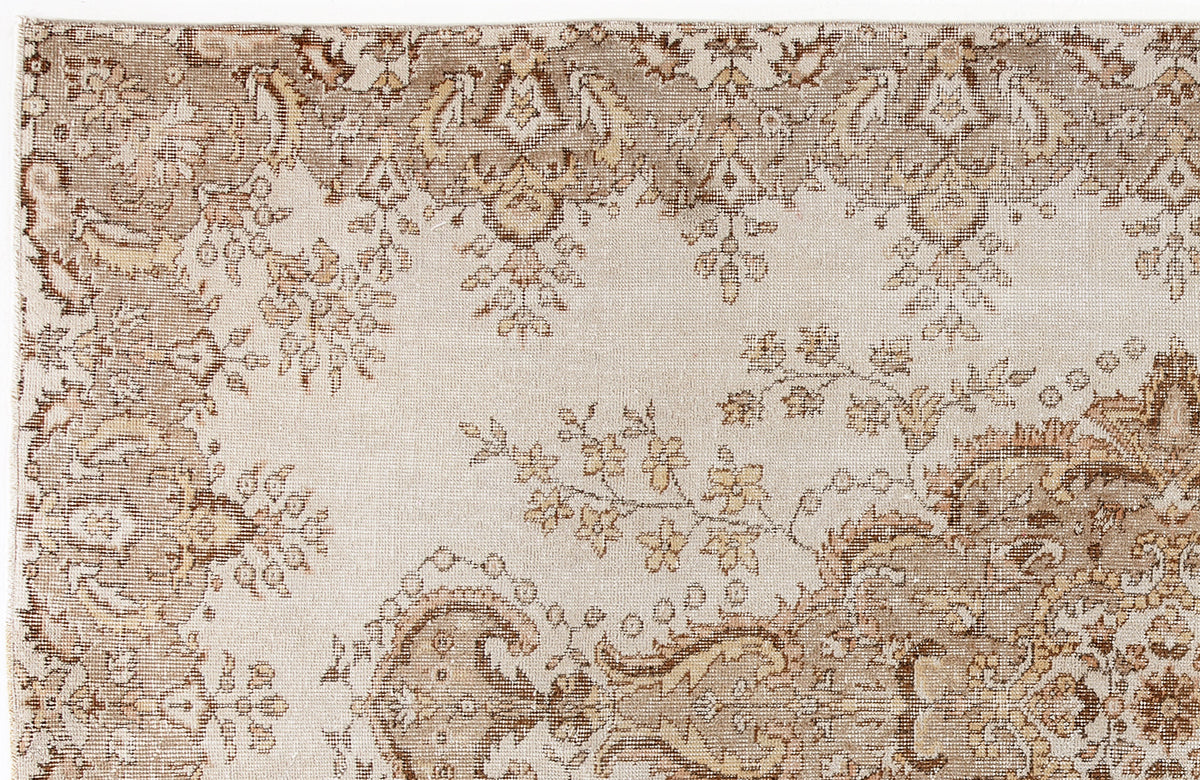 Beige and brown rug with a distressed traditional floral medallion pattern.