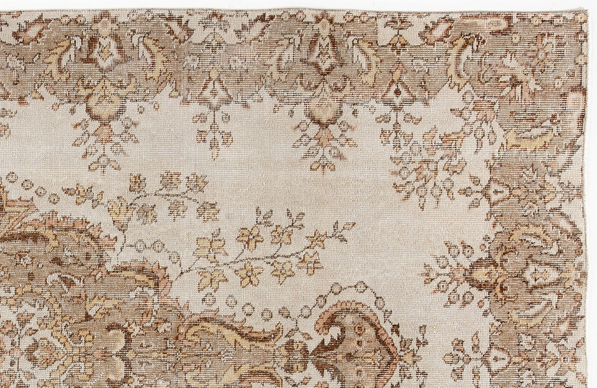 Beige and brown vintage-style rug with a distressed floral medallion pattern on a cream background.