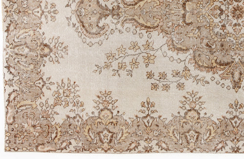 Load image 1 in gallery view. Beige and brown traditional rug with a distressed floral medallion and vine pattern.