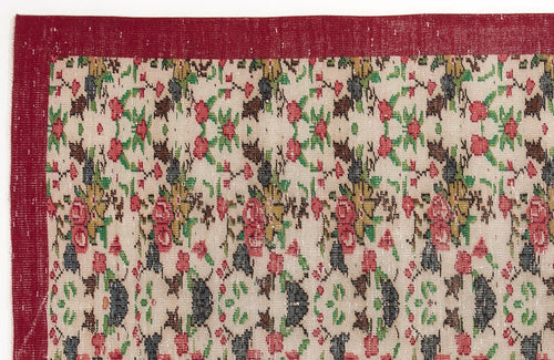 Load image 1 in gallery view. Beige rug with a red border and a repeating floral pattern in red, green, and dark grey.