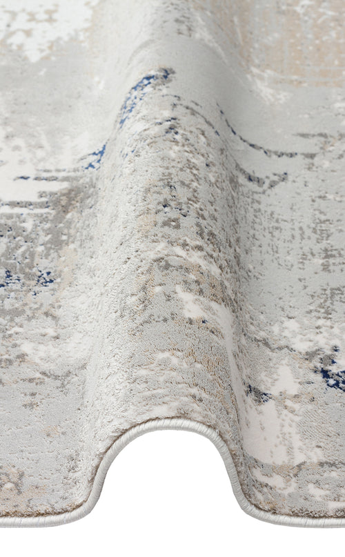 Load image 1 in gallery view. Grey, white, and blue abstract distressed rug with a folded edge on a white background.