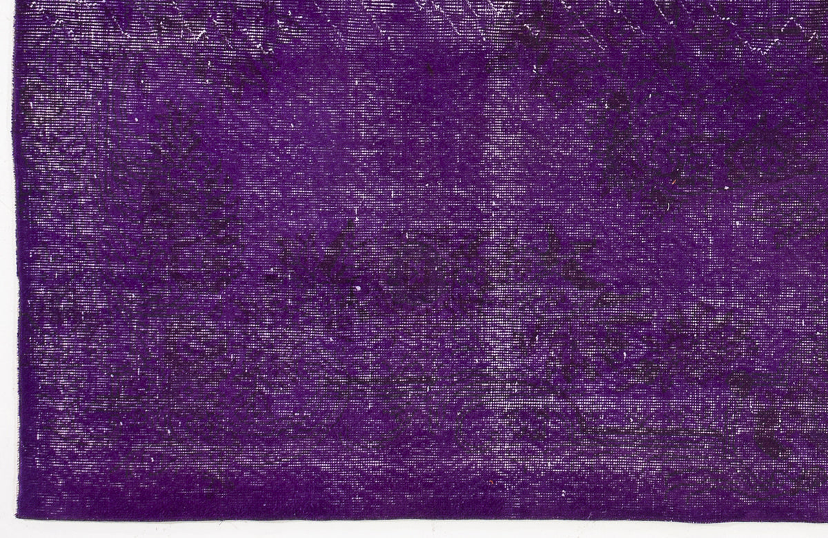 Deep purple vintage-style rug with a distressed, faded black floral medallion pattern.