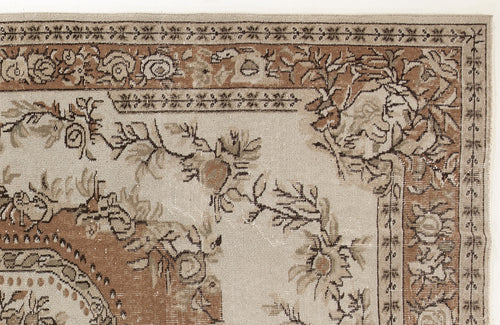 Load image 1 in gallery view. Beige and brown traditional rug with a floral medallion border and intricate vine motifs.