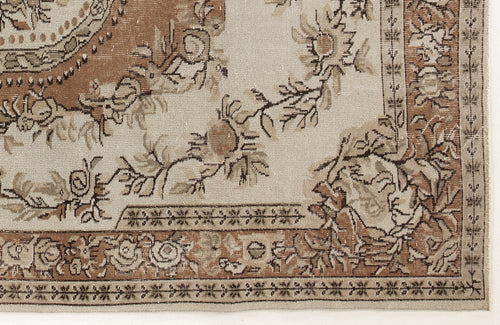 Load image 1 in gallery view. Beige and brown vintage-style rug with a floral medallion pattern and a detailed geometric border.