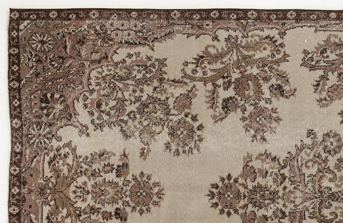 Taupe and brown vintage-style rug with a distressed floral pattern and a decorative border.