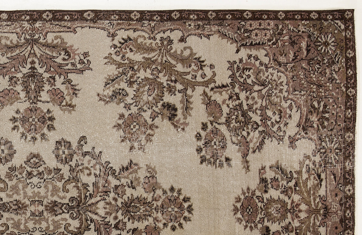 Beige and brown traditional rug with a distressed floral medallion pattern and a detailed border.
