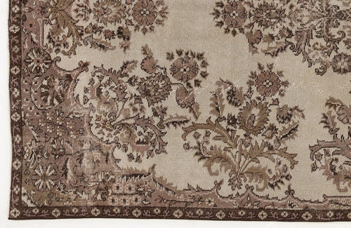 Load image 1 in gallery view. Beige and brown vintage-style rug with a distressed floral medallion pattern and a decorative border.