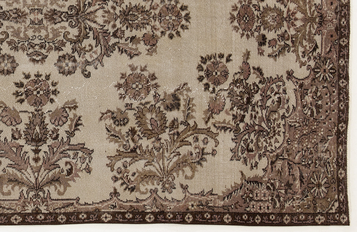 Beige and brown distressed rug with a traditional floral medallion pattern and a dark decorative border.