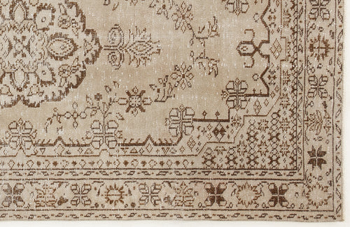 Load image 1 in gallery view. Beige and brown distressed rug with a traditional floral medallion and geometric border pattern.