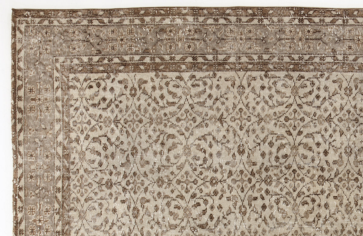 Taupe and brown vintage-style rug with a distressed floral trellis pattern and a decorative border.