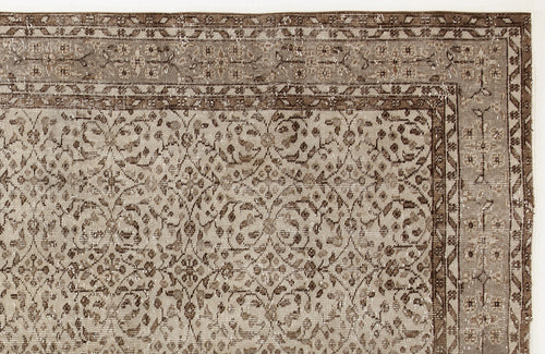 Load image 1 in gallery view. Taupe and brown vintage-style rug with a distressed floral vine pattern and a geometric border.