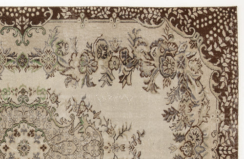 Load image 1 in gallery view. Beige rug with a dark brown floral border and intricate, distressed botanical patterns in green, grey, and brown.