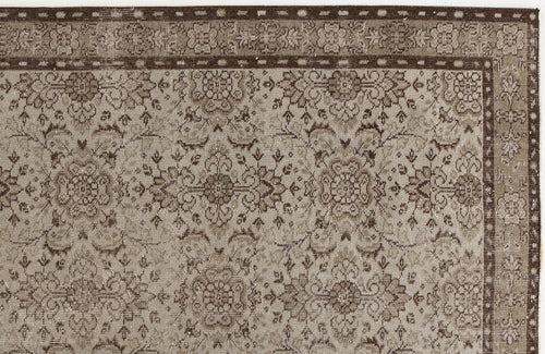 Load image 1 in gallery view. Taupe and dark brown traditional rug with a repeating floral medallion pattern and a decorative geometric border.
