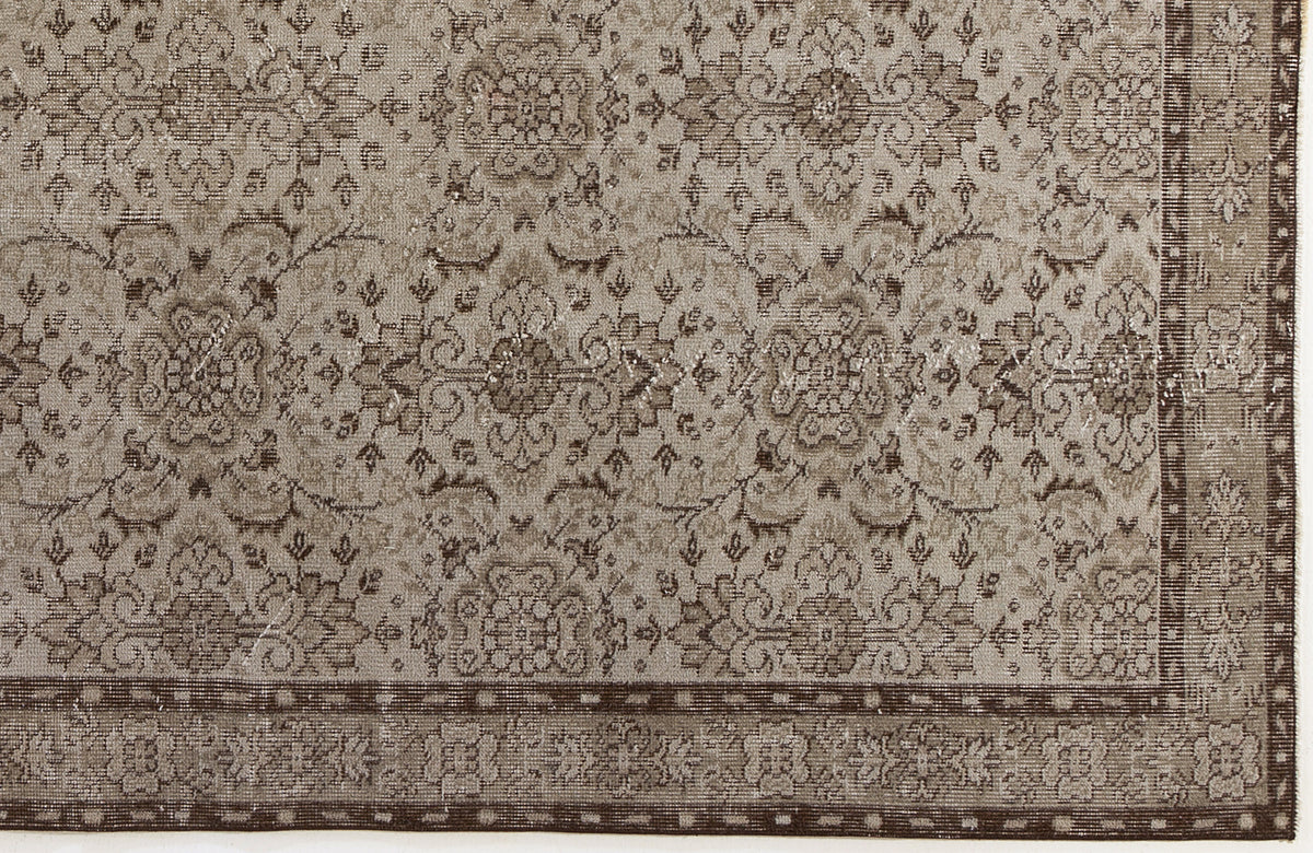 Taupe and dark brown distressed rug with a traditional floral medallion pattern and a decorative border.