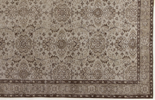 Load image 1 in gallery view. Taupe and dark brown distressed rug with a traditional floral medallion pattern and a decorative border.