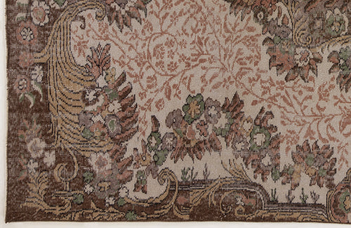 Load image 1 in gallery view. Traditional rug with a brown border and intricate floral and vine patterns in muted green, terracotta, and beige.