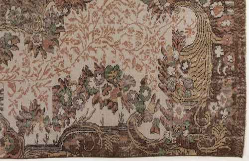 Load image 1 in gallery view. Traditional rug with a beige field and brown border featuring intricate floral and vine motifs in green and muted pink.