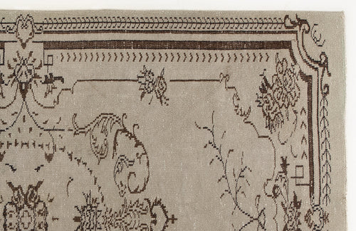 Load image 1 in gallery view. Taupe rug with a dark brown traditional floral border and sparse, stylized botanical motifs.