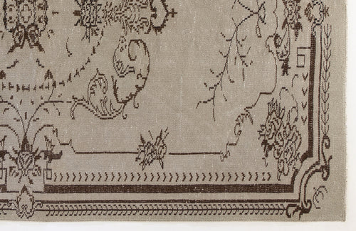 Load image 1 in gallery view. Taupe rug with a dark brown distressed floral medallion pattern and a geometric border.