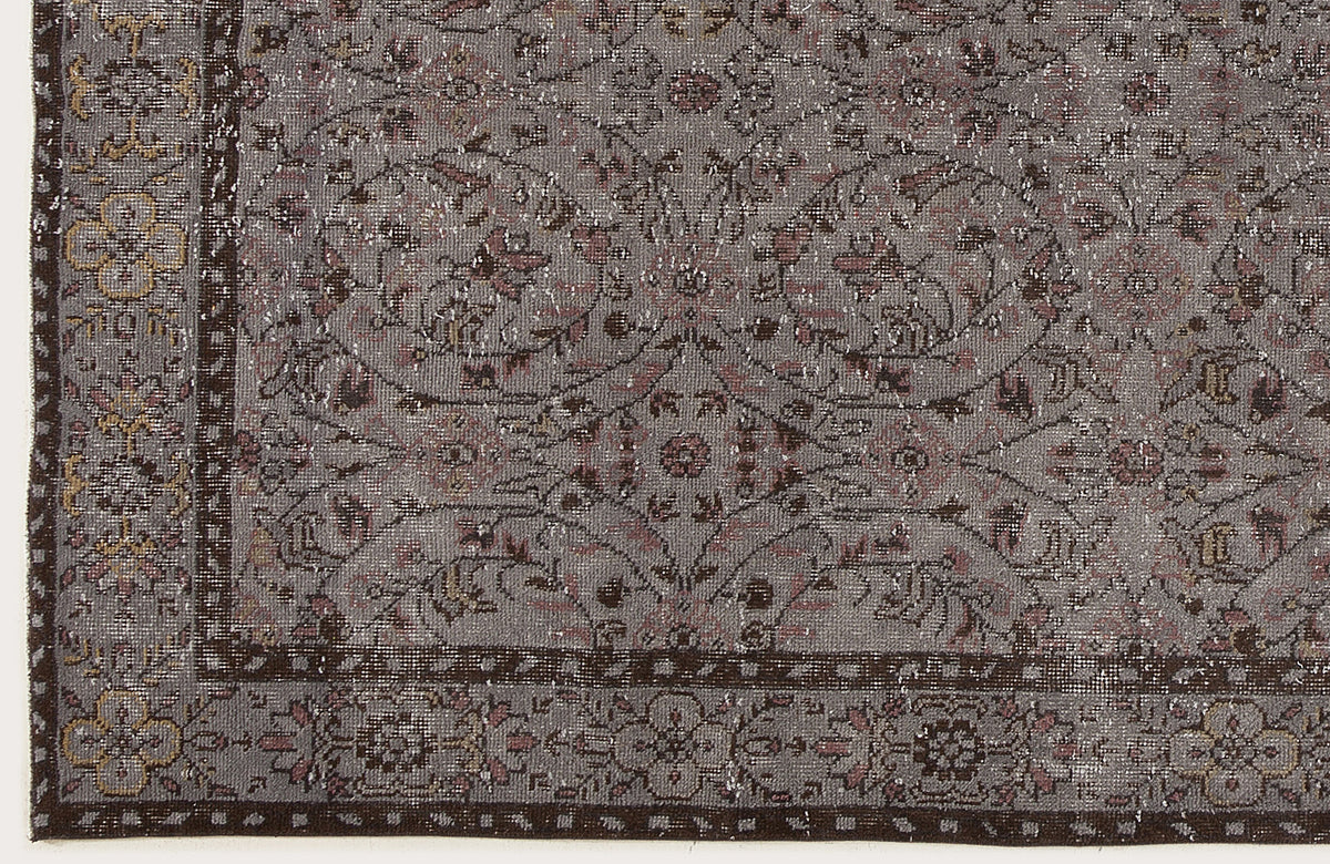 Grey and brown vintage-style rug with a distressed floral medallion pattern and a detailed border.