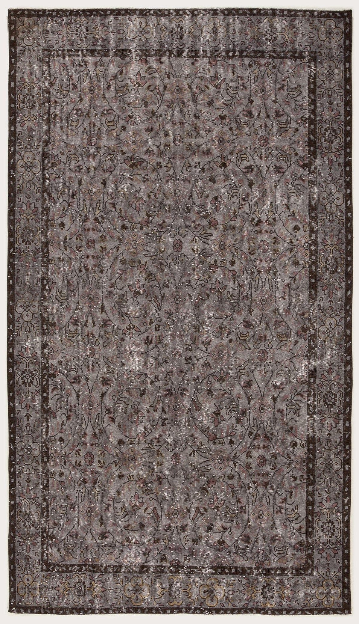 Grey and brown vintage-style rug with a distressed floral medallion pattern and a dark decorative border.