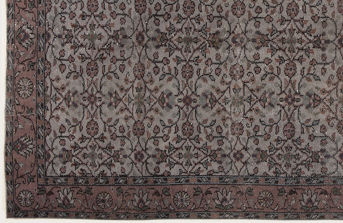 Grey and mauve traditional rug with a repeating floral vine pattern and a decorative border.