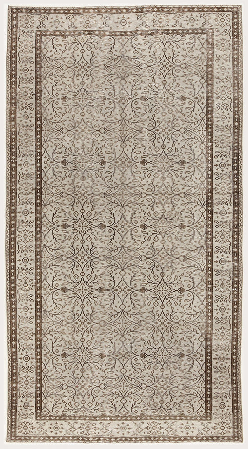 Load image 1 in gallery view. Beige and brown vintage-style rug with a repeating floral medallion pattern and a decorative geometric border.