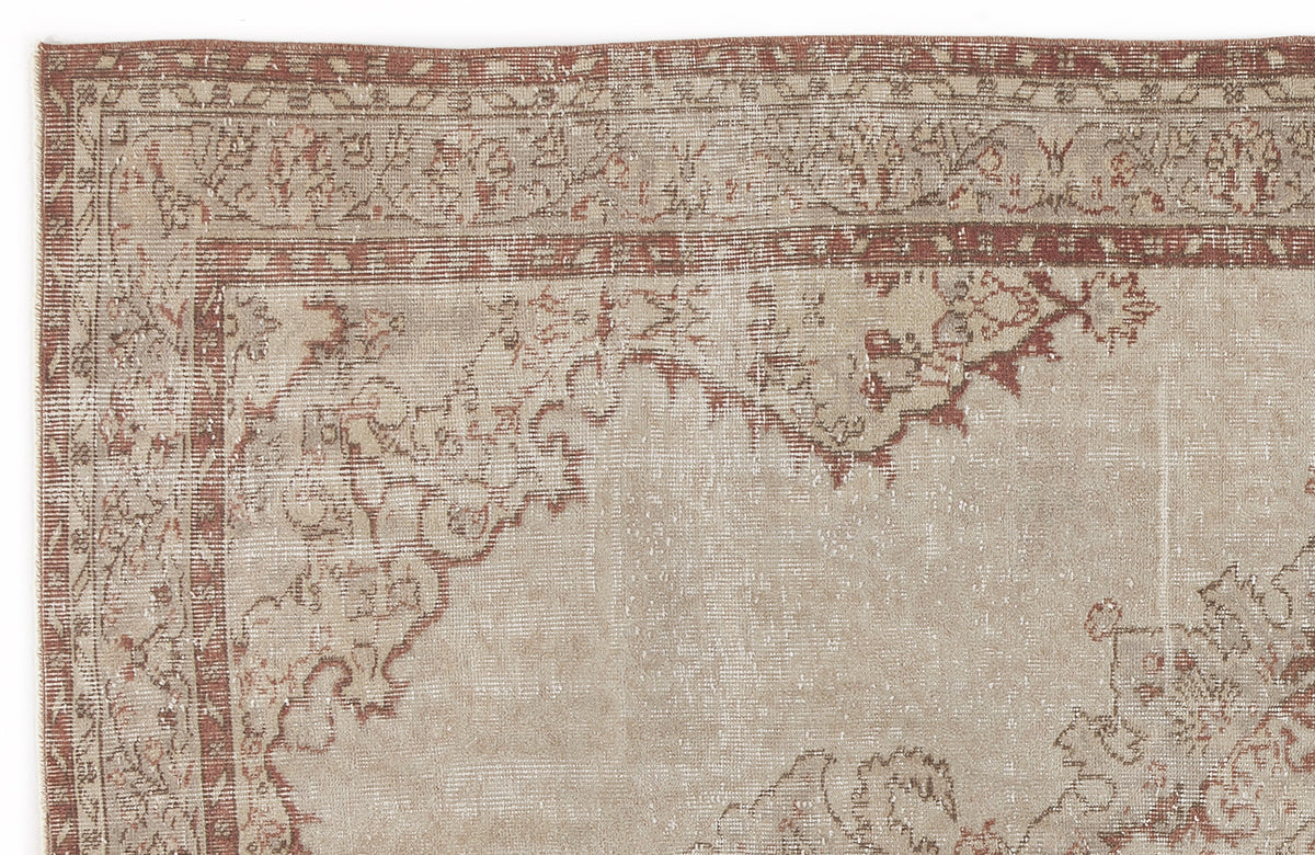 Distressed beige and terracotta rug with a traditional floral medallion border and faded central pattern.