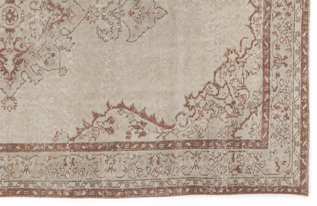 Beige and terracotta distressed rug with a traditional floral medallion pattern and a decorative border.