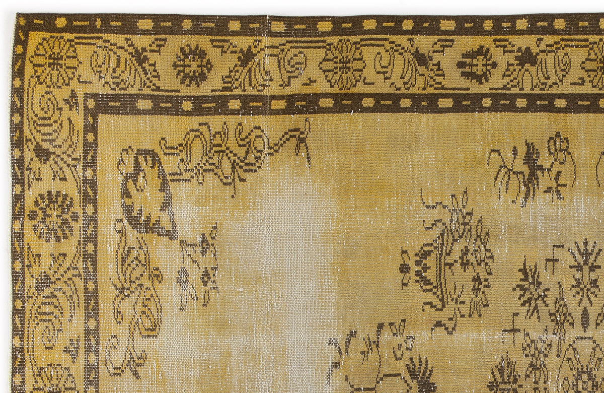 Mustard yellow and dark brown vintage-style rug with a distressed floral border and central medallion pattern.