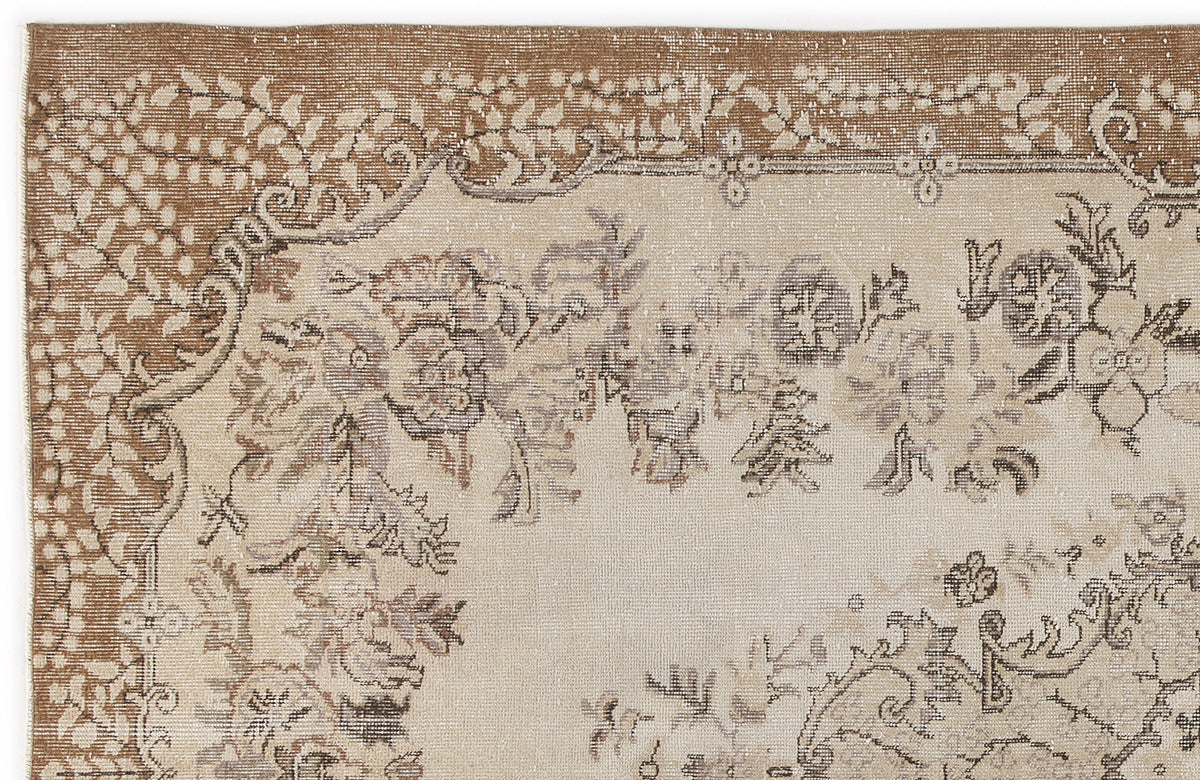Tan and cream vintage-style rug with a distressed floral medallion pattern and ornate border.