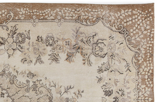 Load image 1 in gallery view. Beige and brown vintage-style rug with a distressed floral medallion pattern and a decorative leaf border.