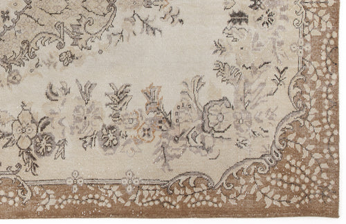 Load image 1 in gallery view. Beige and brown vintage-style rug with a distressed floral medallion pattern and a detailed border.