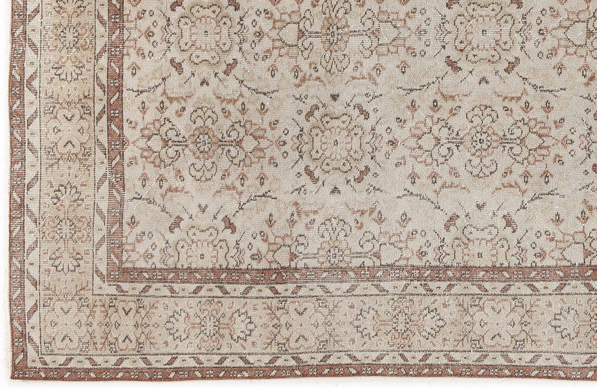 Beige and terracotta distressed rug with a traditional floral medallion pattern and a geometric border.