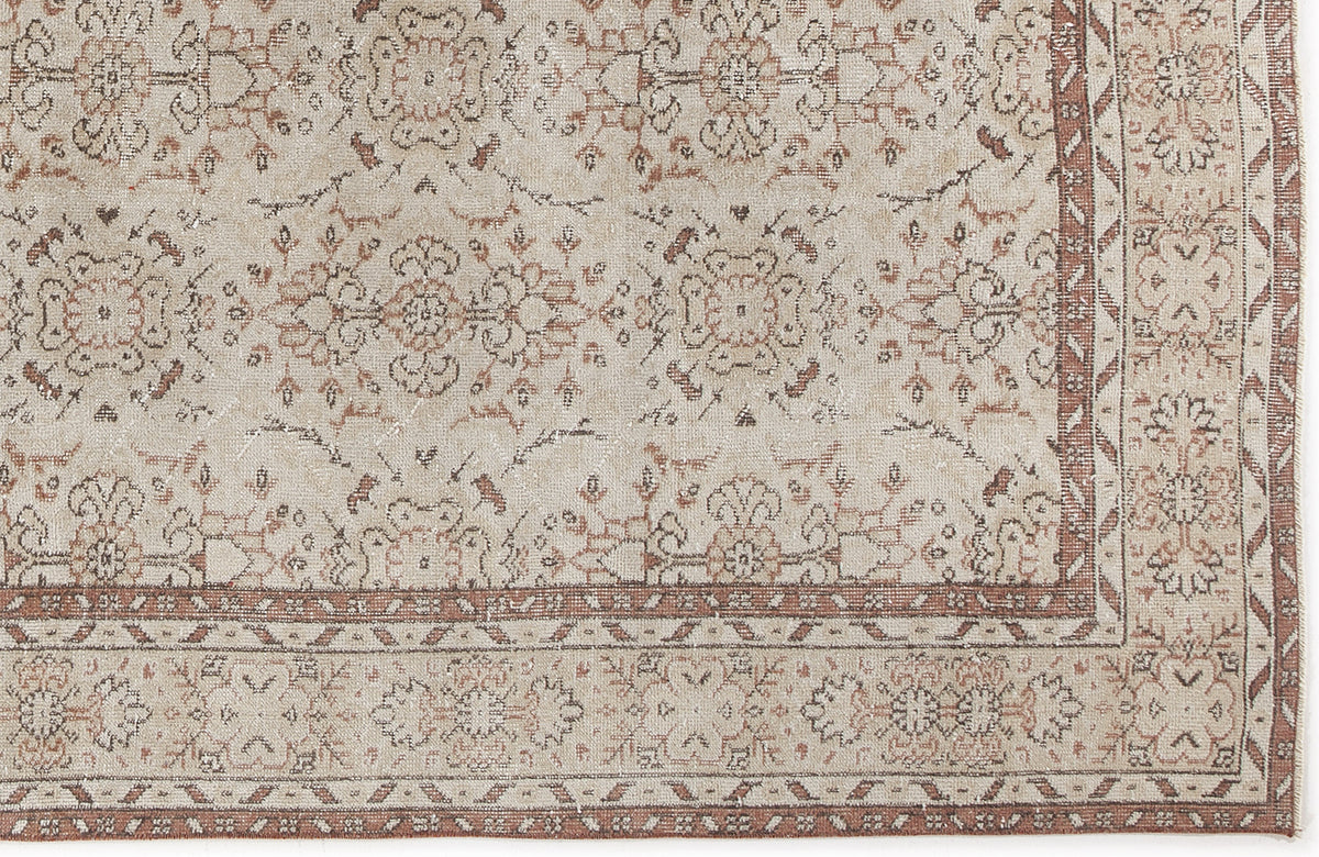 Beige and terracotta traditional rug with a distressed floral medallion pattern and a geometric border.