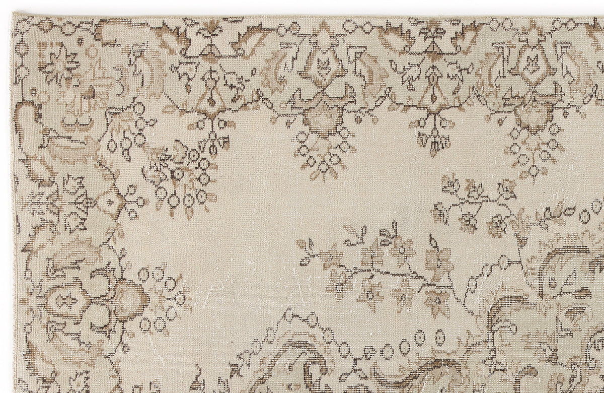 Beige rug with a distressed brown floral and vine pattern on a white background.