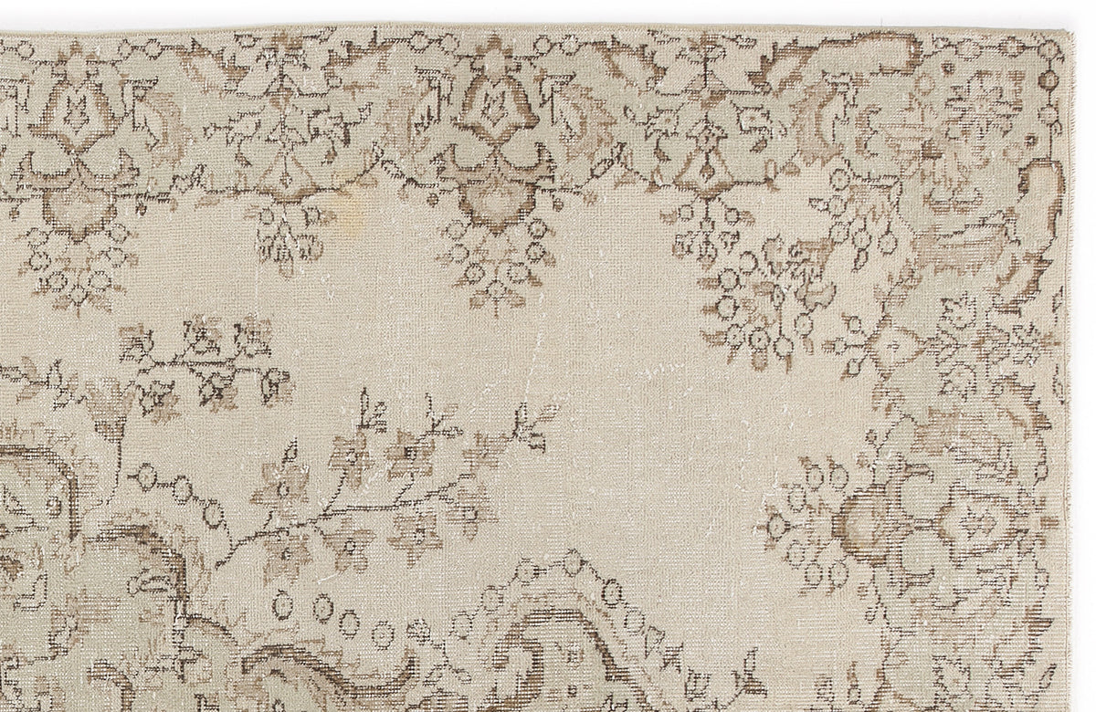 Beige and taupe vintage-style rug with a distressed floral medallion pattern on a white background.