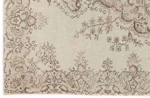 Load image 1 in gallery view. Beige and taupe vintage-style rug with a distressed floral medallion and vine pattern.