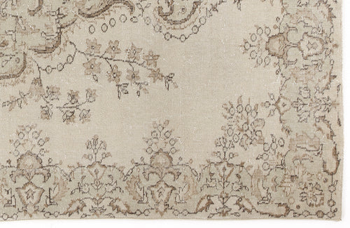 Load image 1 in gallery view. Beige and taupe distressed rug with a faded floral medallion and vine pattern.