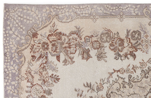 Load image 1 in gallery view. Distressed beige, lavender, and brown rug with a traditional floral border and medallion pattern.