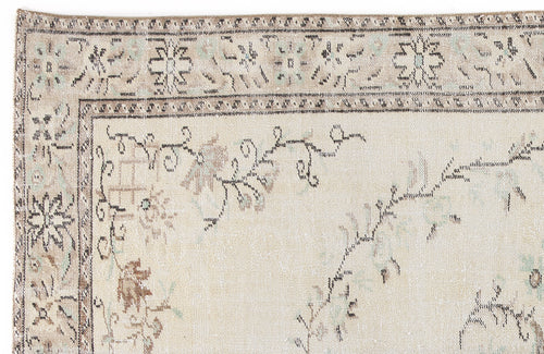 Load image 1 in gallery view. Beige and cream traditional rug with a distressed floral border and sparse vine motifs.