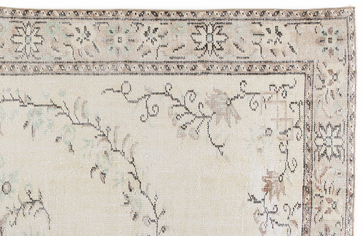 Beige rug with a distressed floral medallion border and faded vine motifs in muted brown and soft blue.