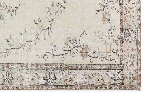 Load image 1 in gallery view. Beige rug with a distressed floral vine pattern and a dark brown geometric border.