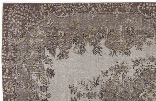 Load image 1 in gallery view. Brown and grey distressed rug with a traditional floral medallion pattern and ornate border.