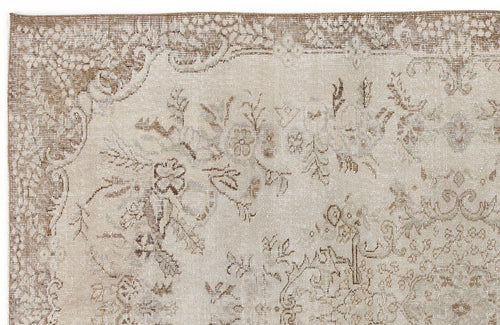 Load image 1 in gallery view. Beige and taupe distressed rug with a faded floral medallion pattern.
